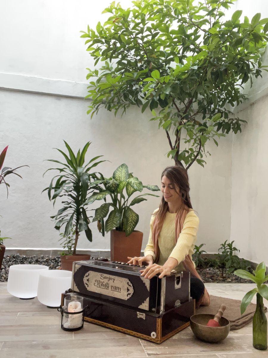 Ceci Molina sonriendo mientras toca el armonio en el patio