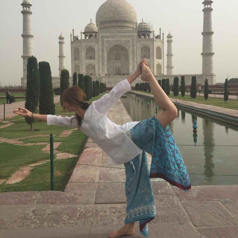 Ceci en una postura de yoga frente al Taj Mahal